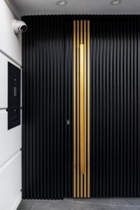 דלת כניסה בקו אפס, בחיפוי אלומיניום שחור ואלומיניום בצבע זהב